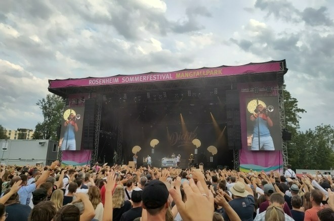 Foto: Die Festival-Bühne. Ein Musiker mit Trompete spielt gerade und ist auch auf zwei großen Bildschirmen am Rand der Bühne zu sehen.