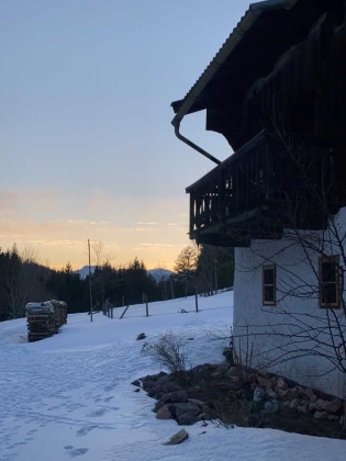 Foto: Ein einsam gelegenes Haus mit Holzbalkon im Abendrot im Schnee
