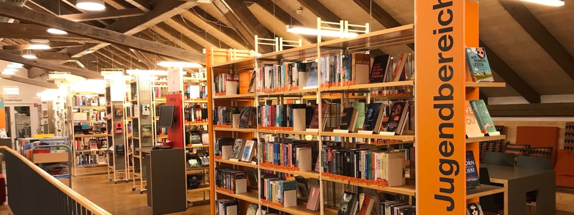 Viel Auswahl... Mehrere Bücherregale mit dem Gerüst einer Treppe. Das ist die Stadtbibliothek Rosenheim, am Aufnahmetag war sie Menschenleer.