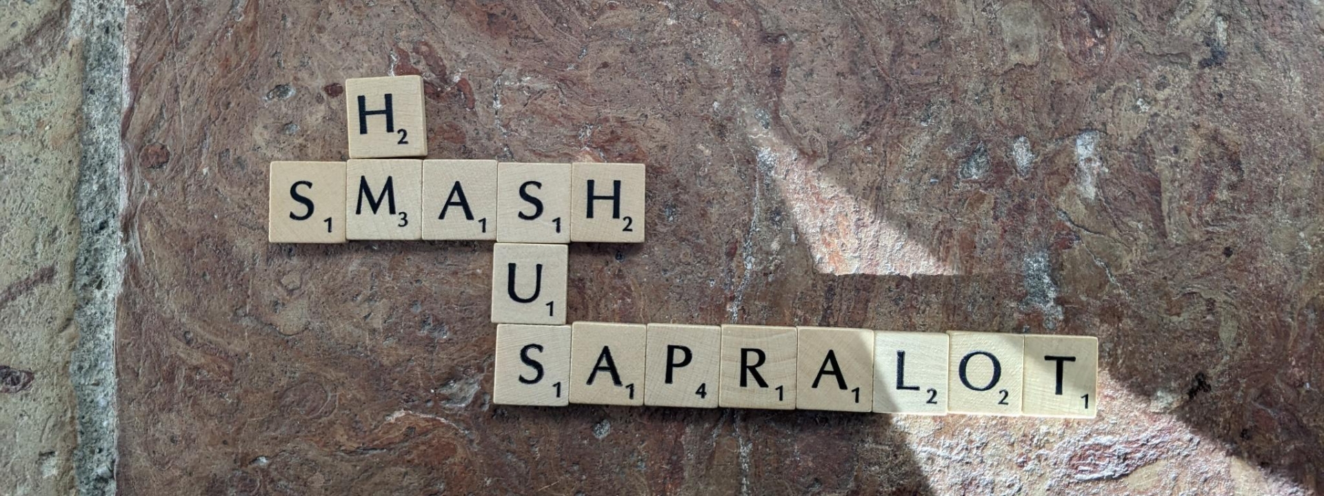 Foto: Buchstaben aus einem Scrabble-Brettspiel bilden die Worte: hm, smash, sus und sapralot.