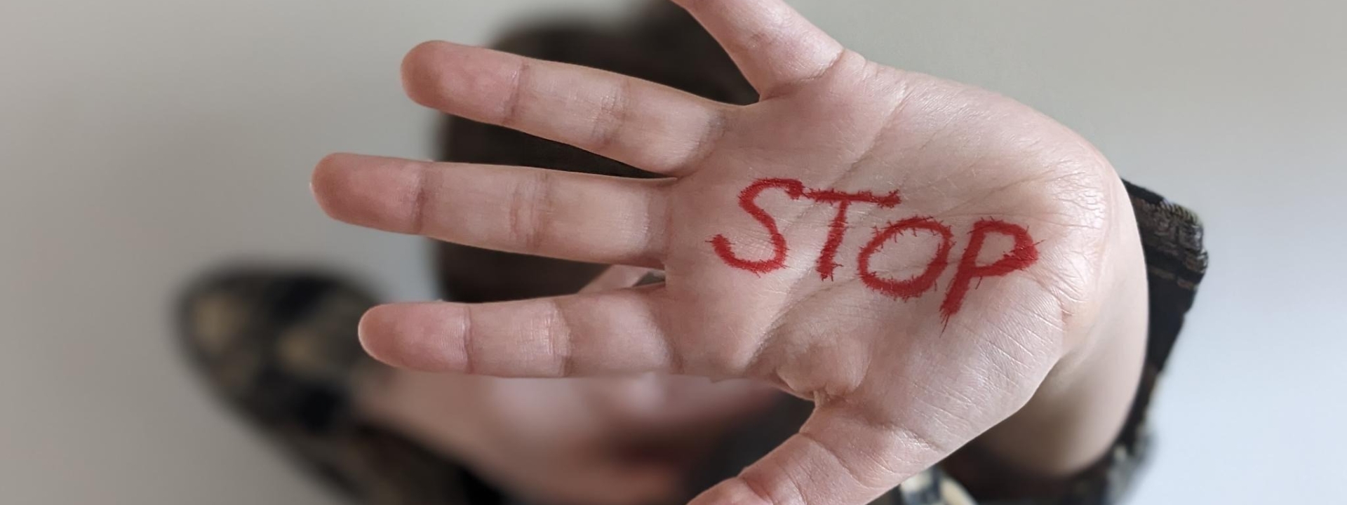 Foto: aROund Foto: Auf einer abwehrend ausgestrecken Hand steht in roten Großbuchstaben das Wort STOP