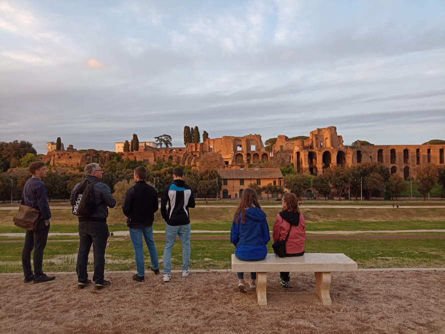 Foto: sechs Menschen vor den Überresten des Circus Maximus
