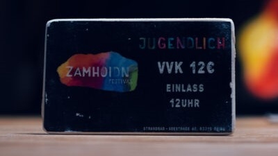 Foto vom Ticket aus Holz in Größe einer Scheckkarte, schwarz mit dem Zamhoidn Logo und der Aufschrift: Jugendliche VVK 12 €