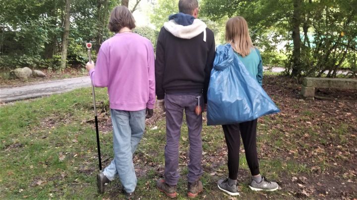 Foto: Drei Personen von hinten mit einem halb vollen blauen Müllsack