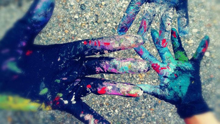 Foto, das drei Hände in Handschuhen zeigt, die voller Gaffiti Farben sind.