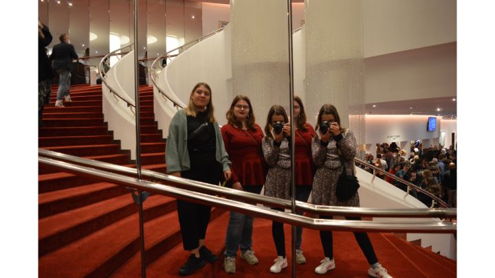 Foto: Ich und meine beiden Freundinnen in einer großen Spiegelwand auf einer roten Treppe.