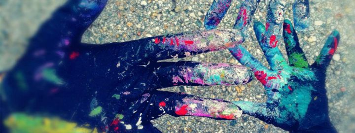 Foto, das drei Hände in Handschuhen zeigt, die voller Gaffiti Farben sind