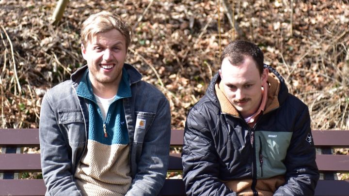 Foto: Gotti und Eisna sitzen auf einer Parkbank, Gotti macht ein ungläubiges Gesicht und Eisna denkt noch nach.