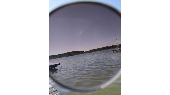 Foto: See durch die Linse einer getönten Sonnenbrille.