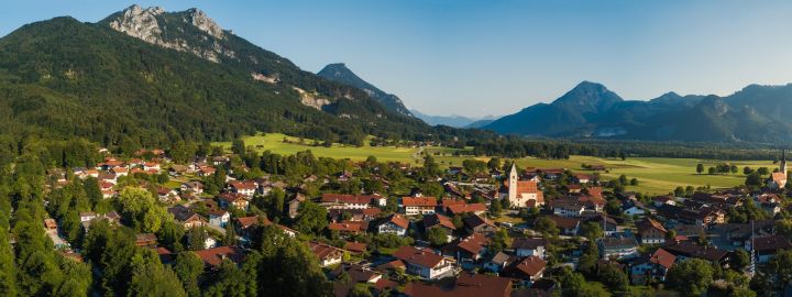 Foto zeigt den Ort Nußdorf aus der Vogelperspektive mit Bergen im Hintergrund