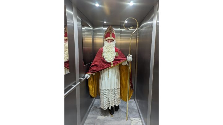 Foto: Der Nikolaus steht im Aufzug und grinst.