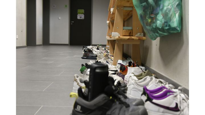 Viele Schuhe aufgereiht an einer Wand